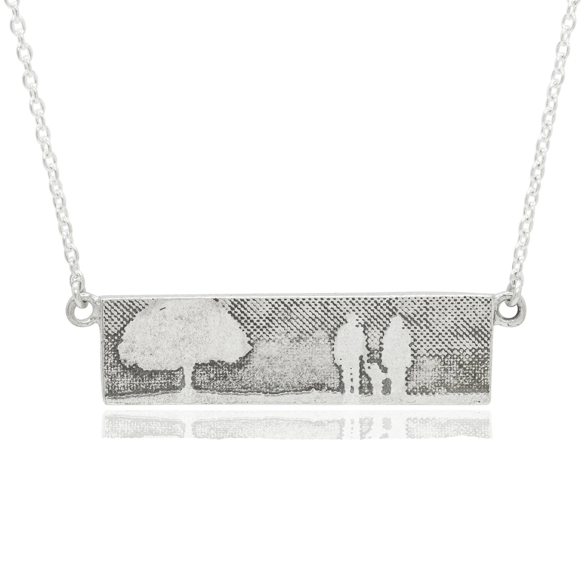 Family Tree Necklace showing a family of three beside a tree.