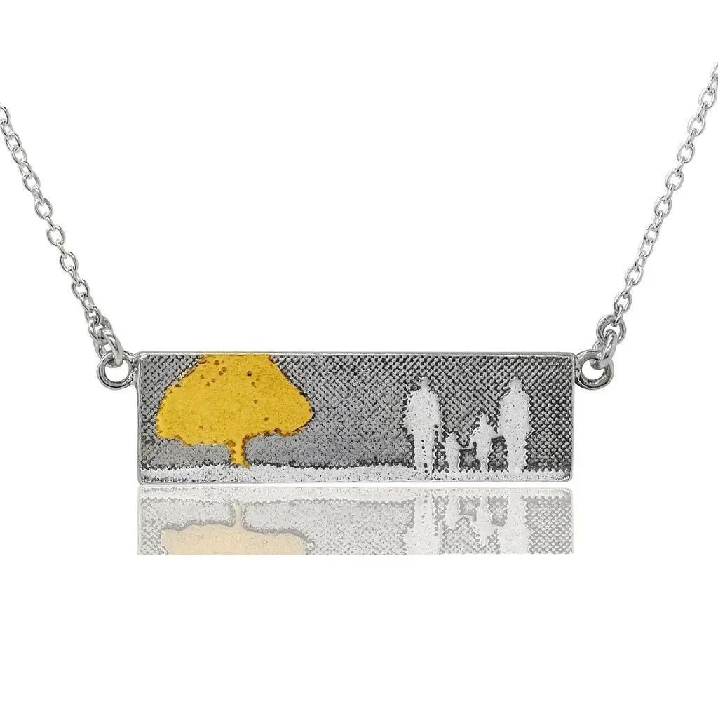 Family Tree Necklace with gold details showing a family of four beside a tree.
