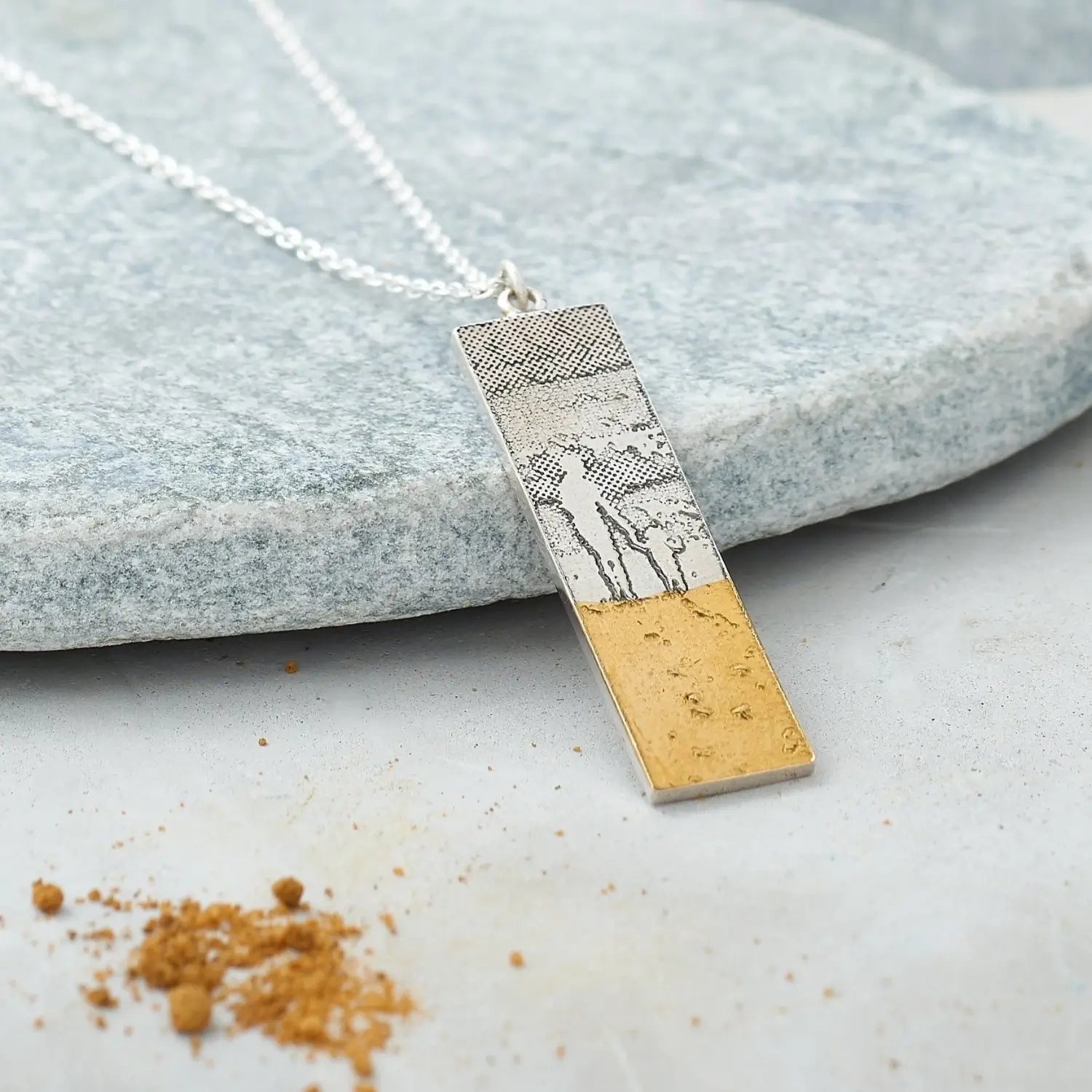 Footprints in the sand mother and child necklace in lifestyle setting.