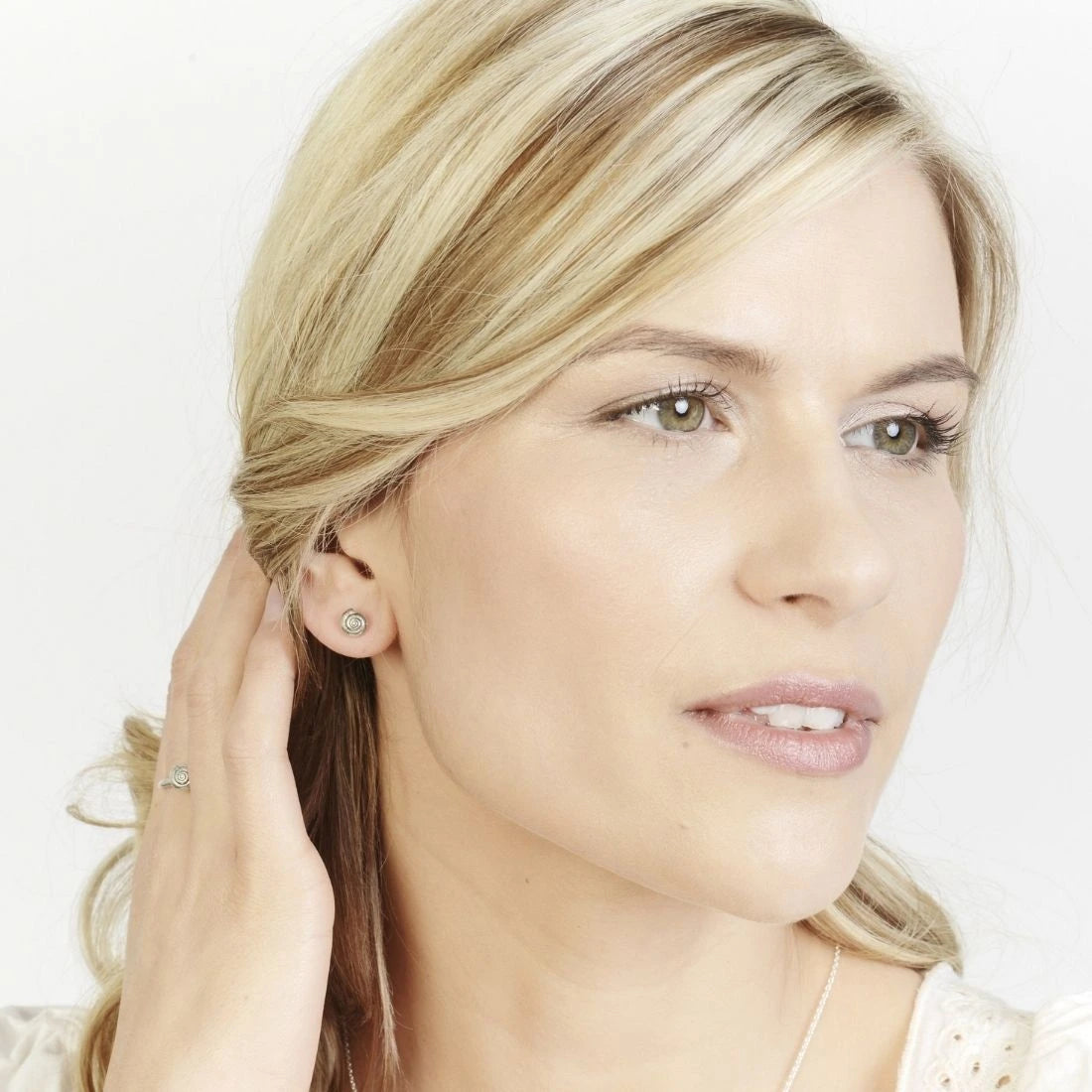 Model wearing the little round silver shell earrings with matching ring.