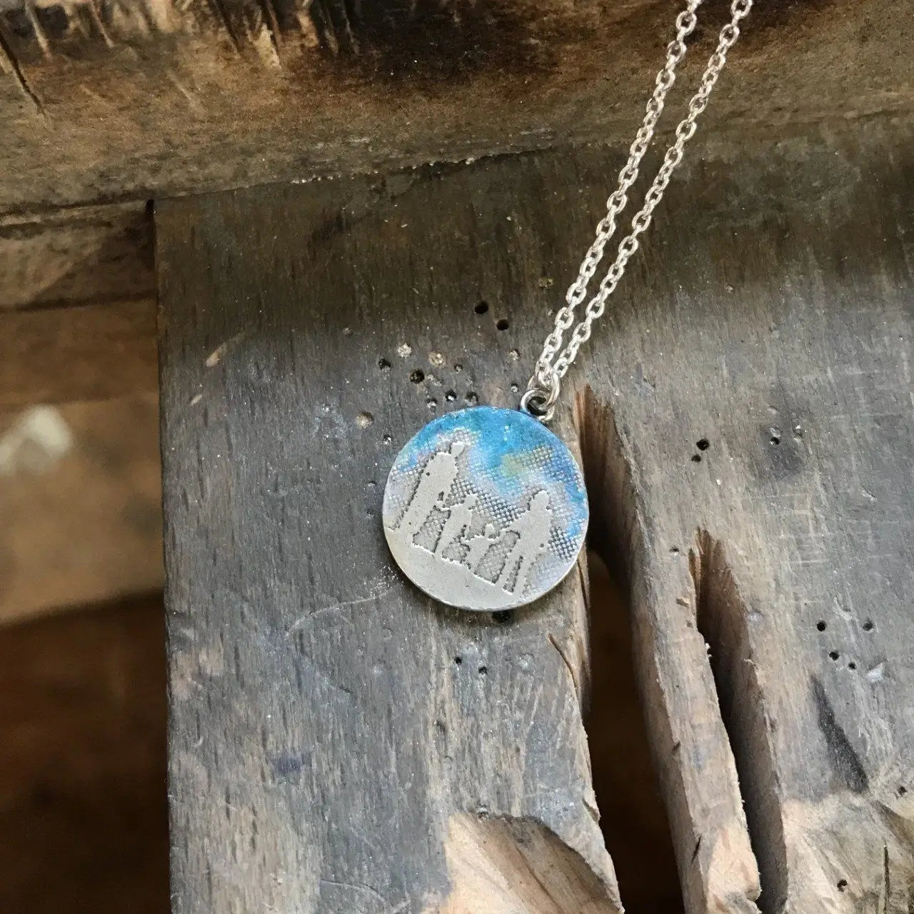 Round Family Necklace with Blue Sky showing a family of four etched in sterling silver