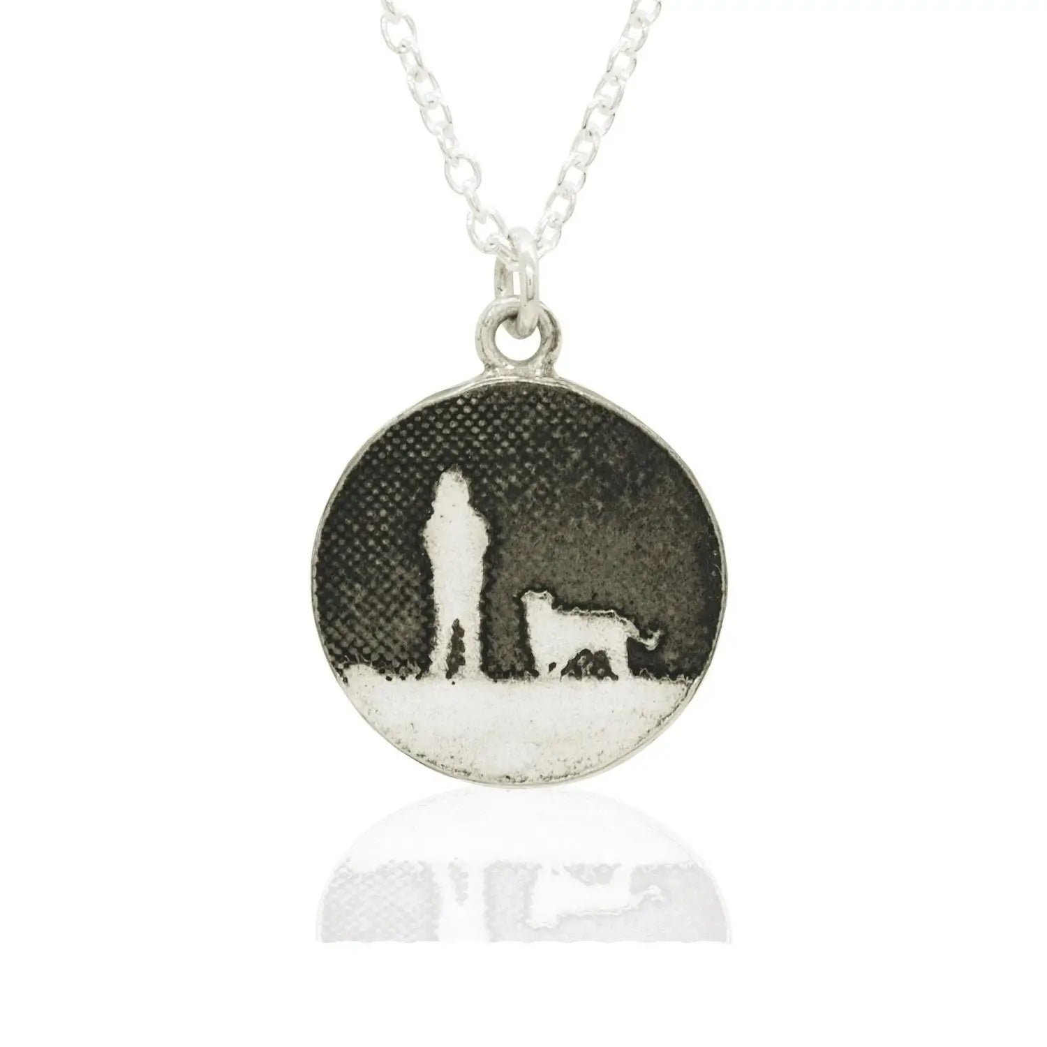 Sterling silver round dog necklace showing a person walking their dog under a moonlit night sky in silhouette.