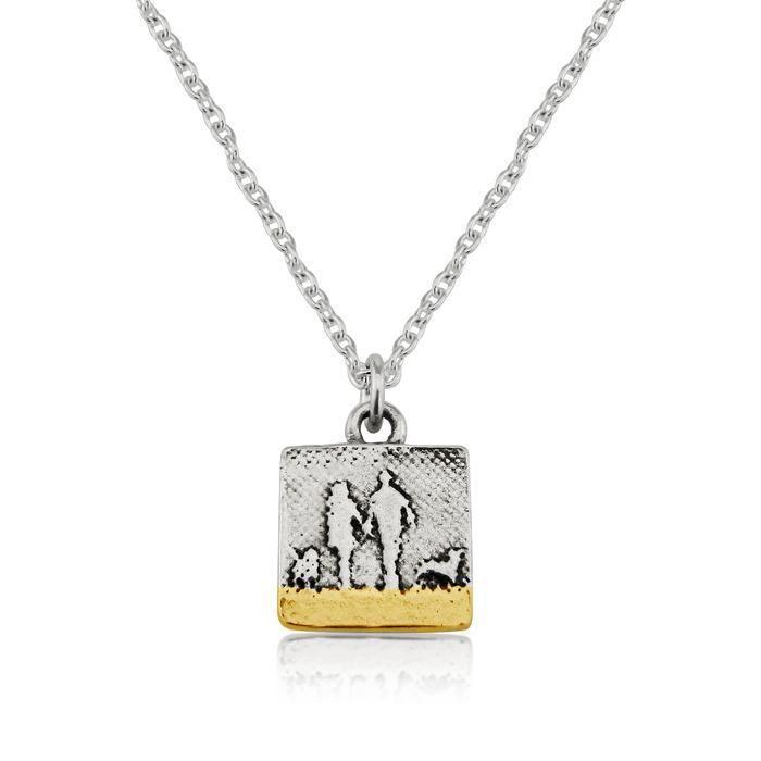 Small sterling silver couple and two dogs necklace with gold beach detail showing two figures walking with their dogs in silhouette.