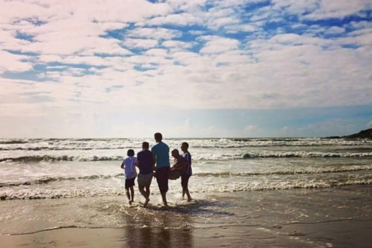 family walking together into the sea on a North Devon beach