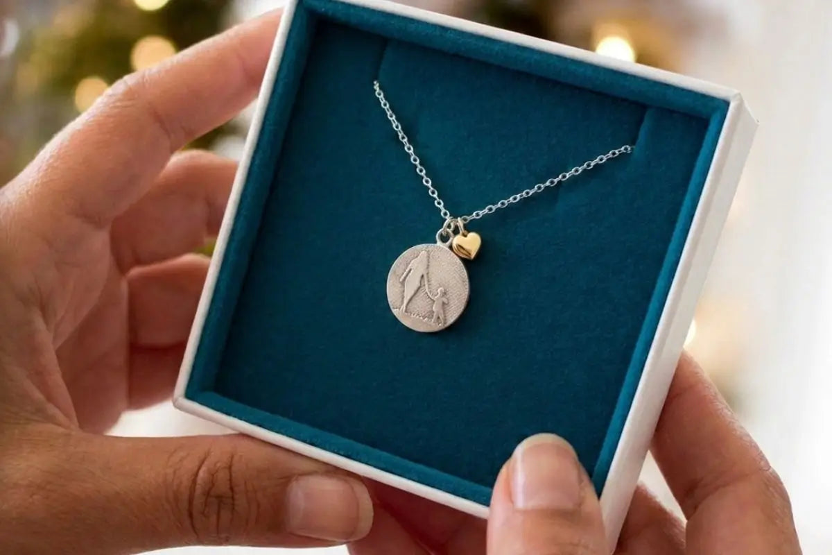 mother and child golden heart necklace in gift box held in woman’s hands