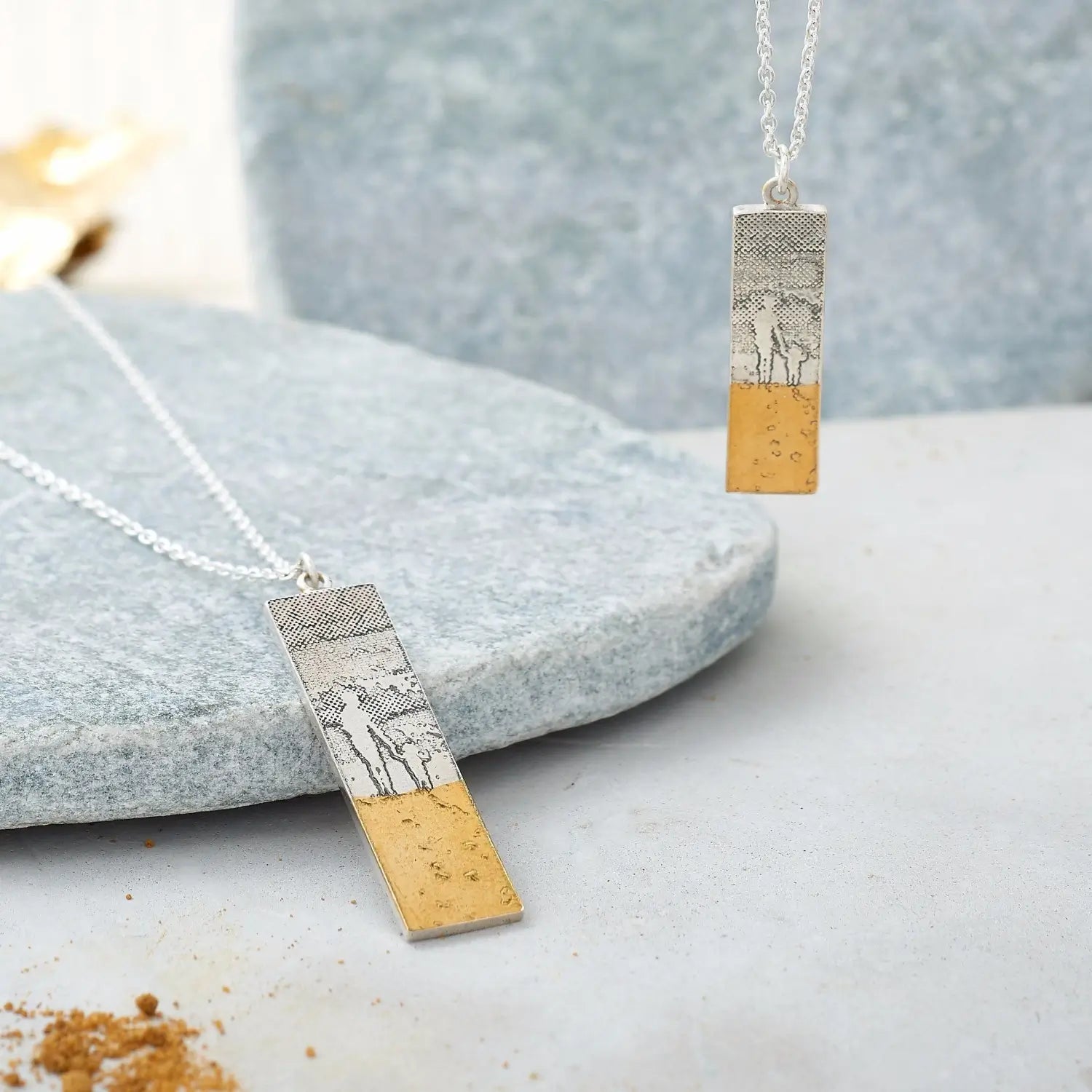Mother and child footprints in the sand necklace shown in small and large sizes – handmade jewellery for mum.