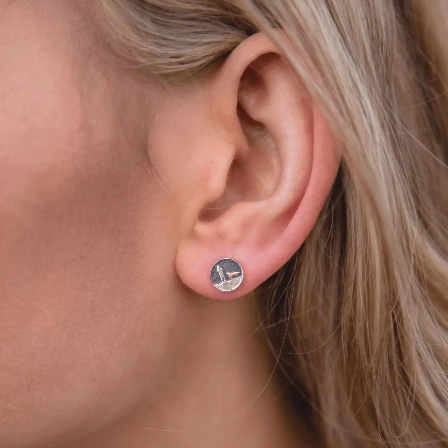 Night’s sky dog stud earrings with gold‑detail dog shown worn on a model’s ear.