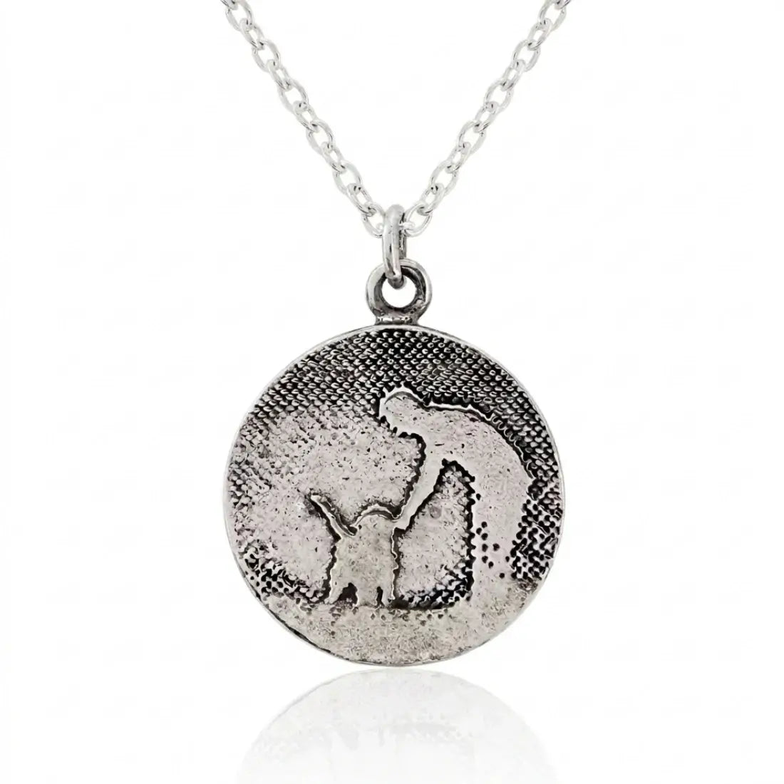 Round sterling silver dog necklace with etched petting silhouette and a soft silver sky finish.