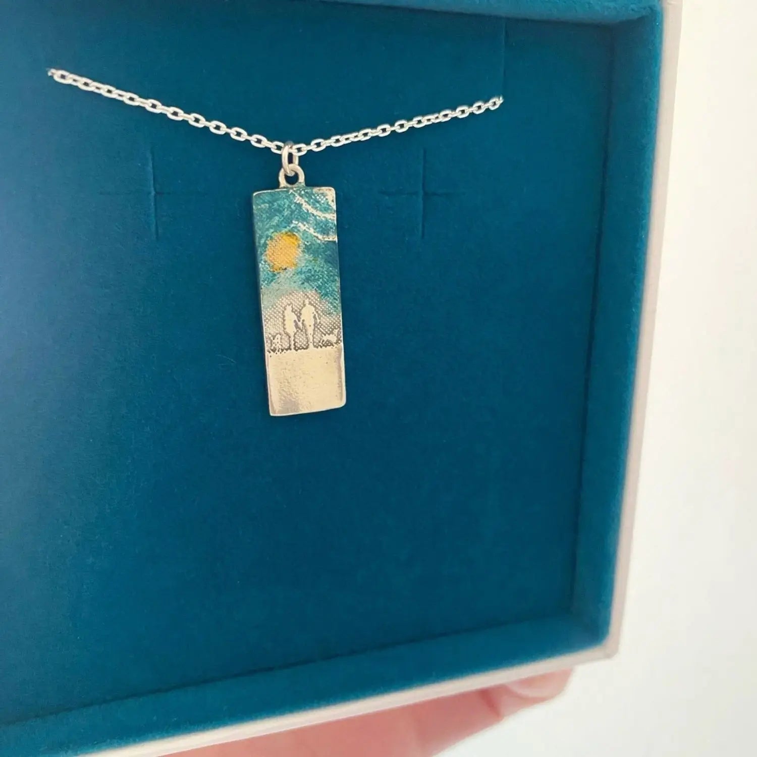 Countryside Couple & Two Dogs Necklace featuring a gold sun and blue enamel sky baked onto the sterling silver silhouette design inspired by open rural landscapes.