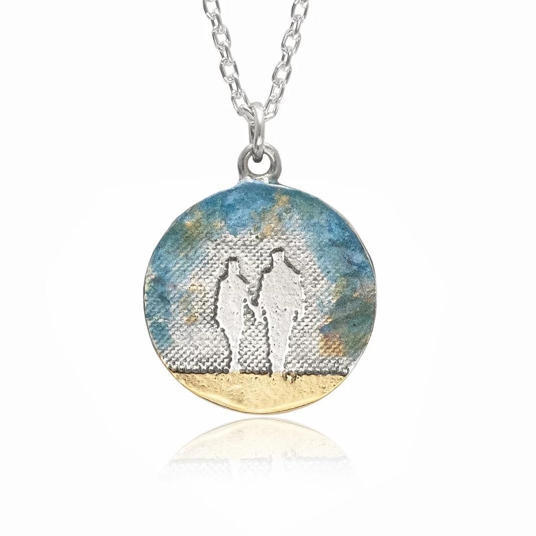 Detail of the optional blue enamel sky baked onto the Round Beach Couple Necklace, inspired by clear coastal skies.