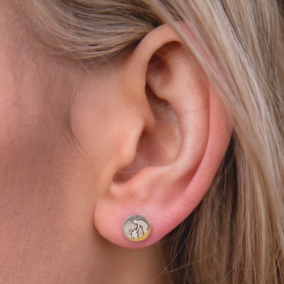 Round beach‑scene dog stud earrings shown worn on a model’s ear, featuring an owner leaning down to pet their dog.