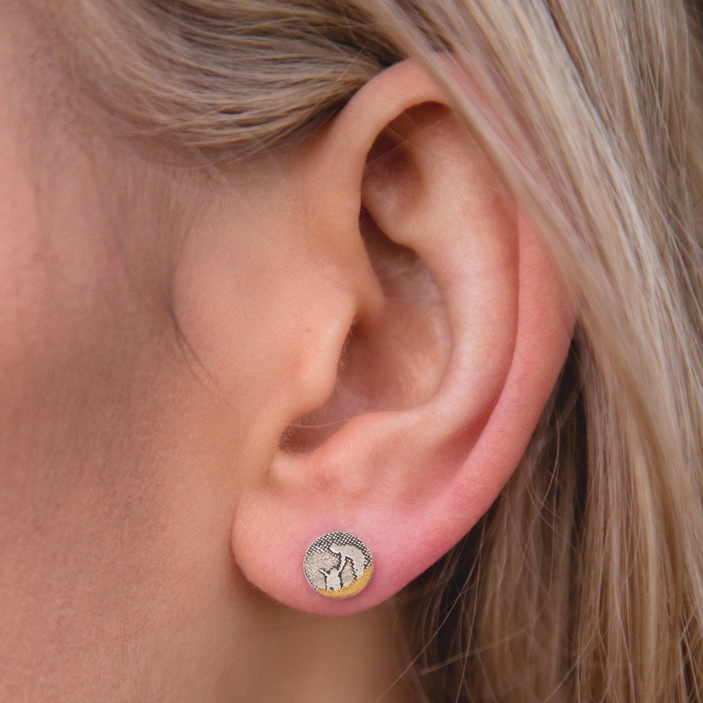 Round beach‑scene dog stud earrings shown worn on a model’s ear, featuring an owner leaning down to pet their dog.