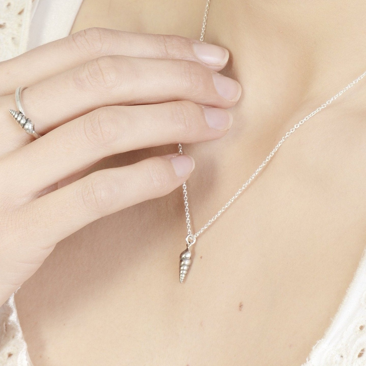Silver spiral seashell necklace on model