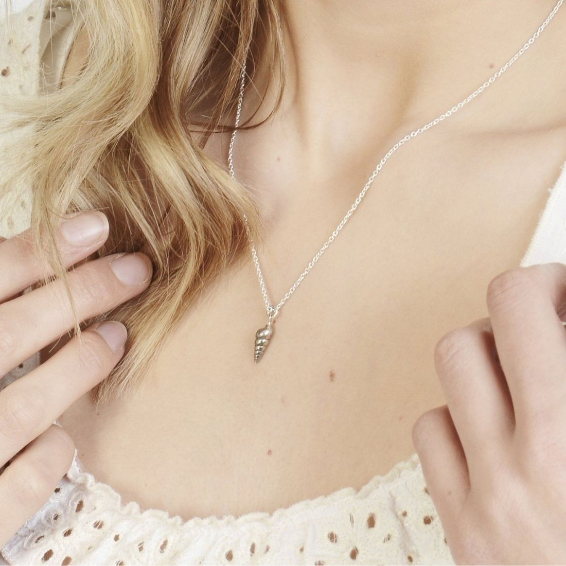 Silver spiral seashell necklace on model