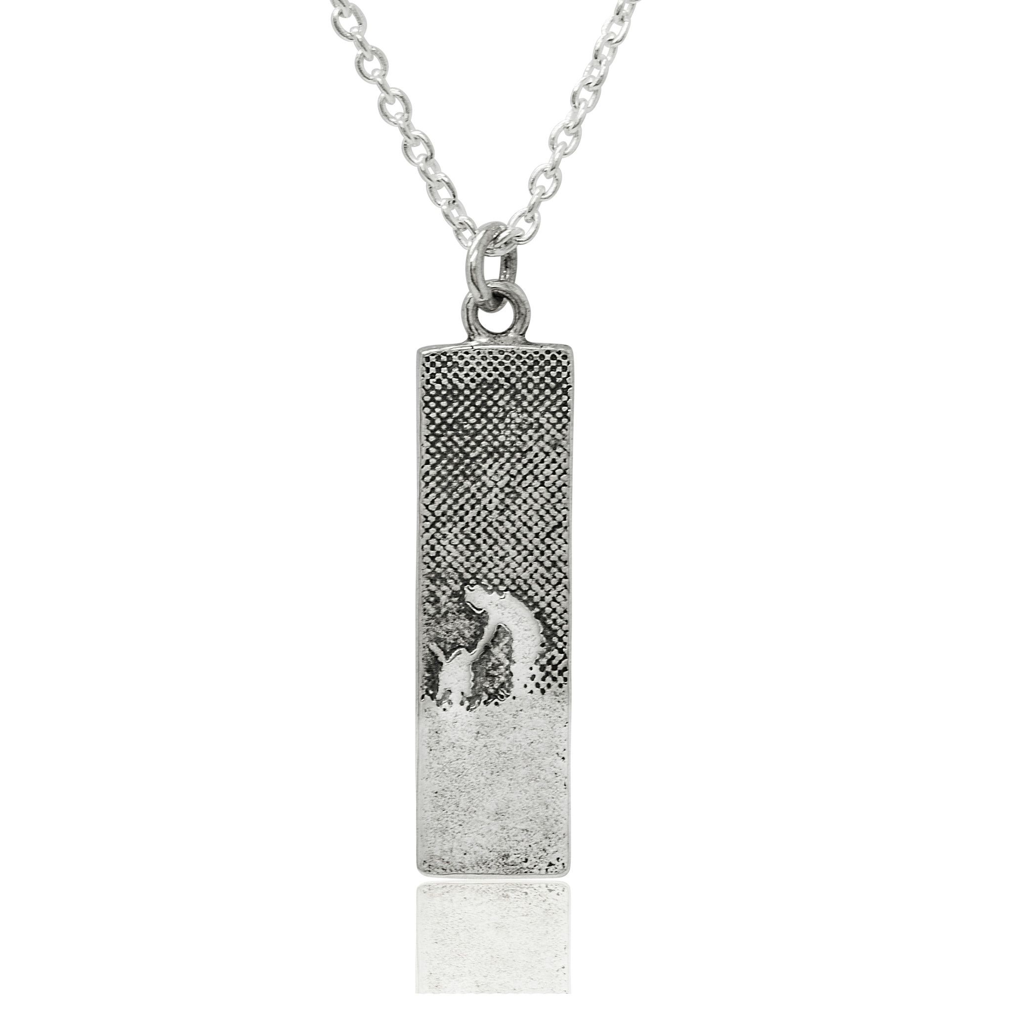 Small sterling silver dog lovers necklace with an etched owner and dog walking through the countryside, shown in a rectangular silhouette with oxidised detail.
