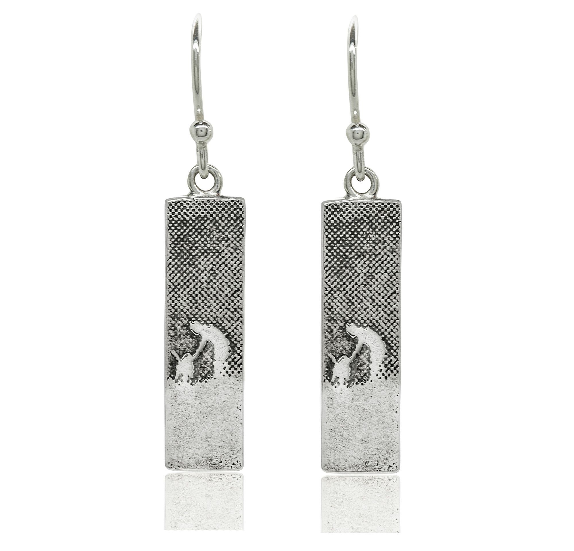 Sterling silver drop earrings etched with a dog and owner sharing a moment of affection.