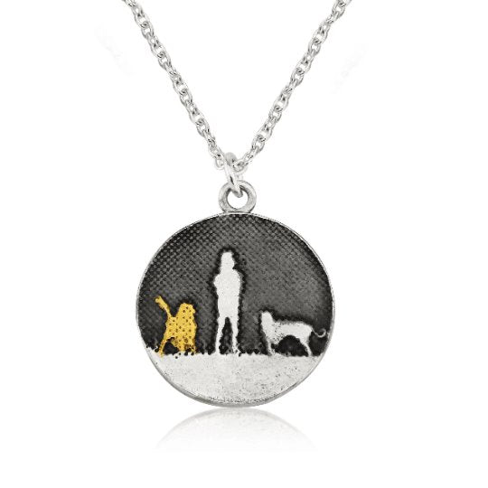 Sterling silver round necklace showing a person walking with one gold‑vermeil dog and one silver dog under the night sky.